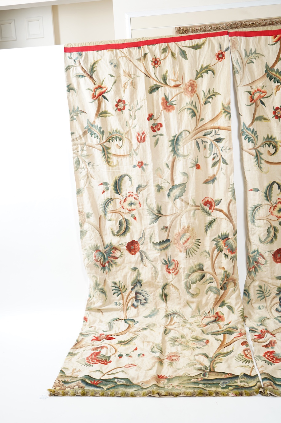 Six 20th century crewel work ‘Tree of Life’ cream linen curtains. Worked at the base in coloured wools depicting a pastoral scene of a shepherd playing a flute amongst sheep, deer, squirrels and flowers with a dog chasin